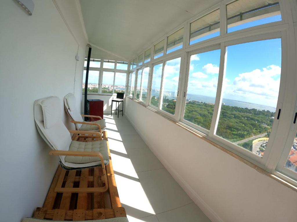 una stanza con sedie e finestre in un edificio di Almada apartamento T1 - 1 Renovado, Laranjeiro ad Almada