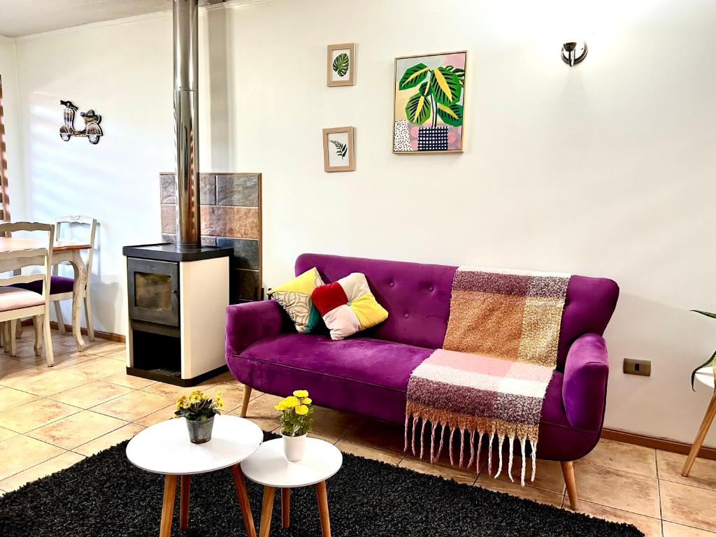 sala de estar con sofá púrpura y mesas en Casa sector residencial 3 dormitorios, en Puerto Montt