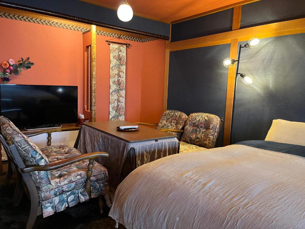 1 dormitorio con 1 cama, mesa y sillas en とれるの【TORERUNO】 en Takayama