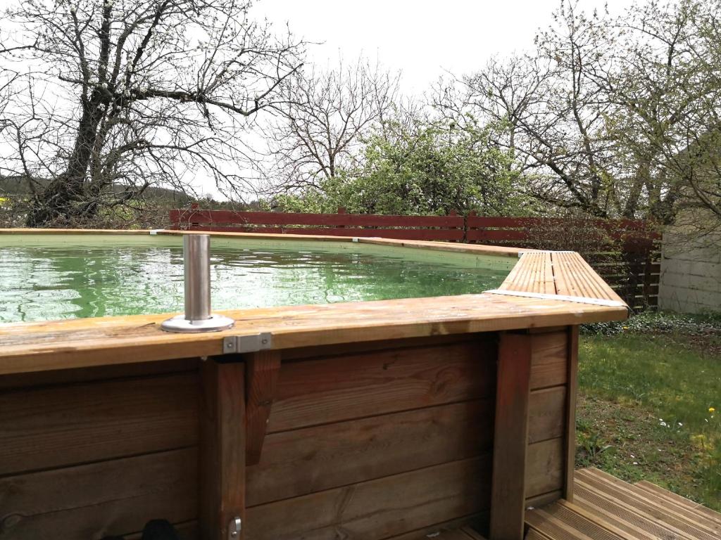 einen Pool auf einer Terrasse mit einer hölzernen Plattform in der Unterkunft Maison de famille piscine et vue in Sougères-en-Puisaye