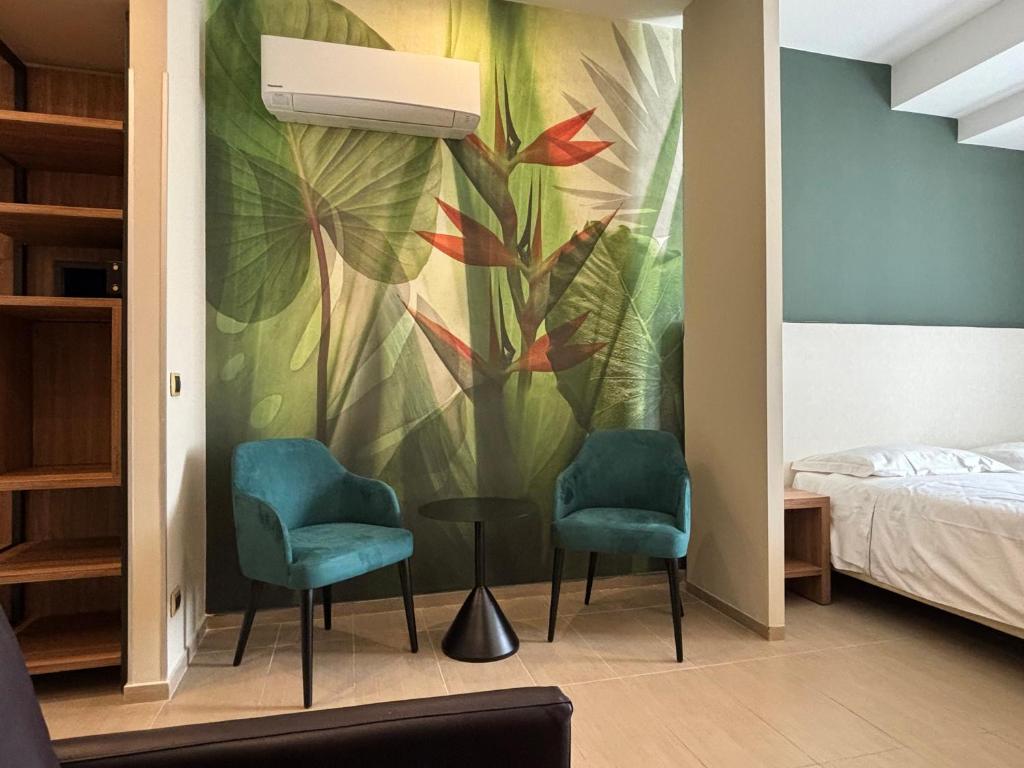 a bedroom with two chairs and a wall mural at Casa Vacanze Fardella Centrale in Trapani