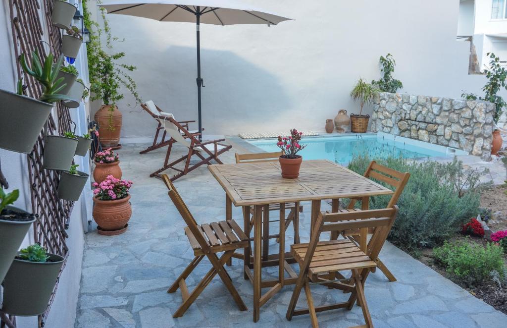 een patio met een tafel en stoelen en een zwembad bij Anassa Mountain House in Émbonas