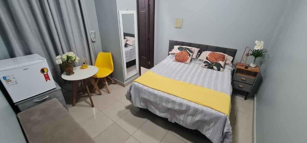 Habitación pequeña con cama, mesa y espejo. en Hostel Cidade Velha, en Belém