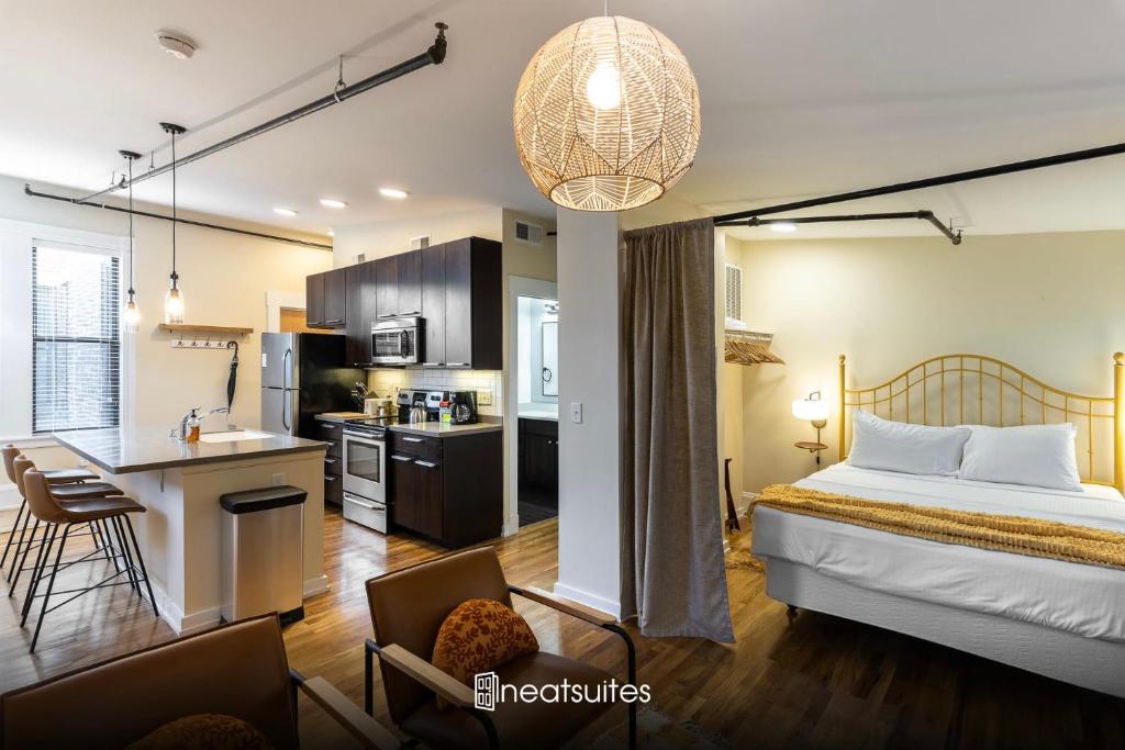 a hotel room with a bed and a kitchen with a counter at The Heart of OTR - Central studio apartment in Cincinnati