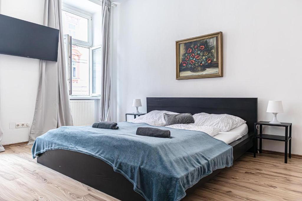 a bedroom with a large bed with a blue blanket at Budget Apartments Well connected to the Whole City in Vienna
