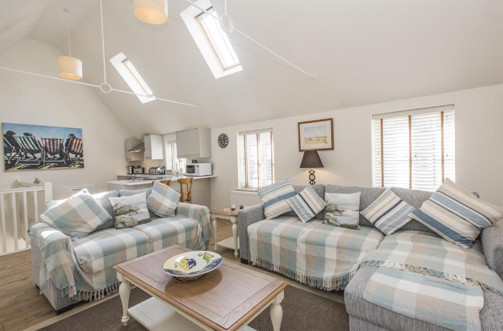 a living room with two couches and a table at Black Lion Court in Little Walsingham