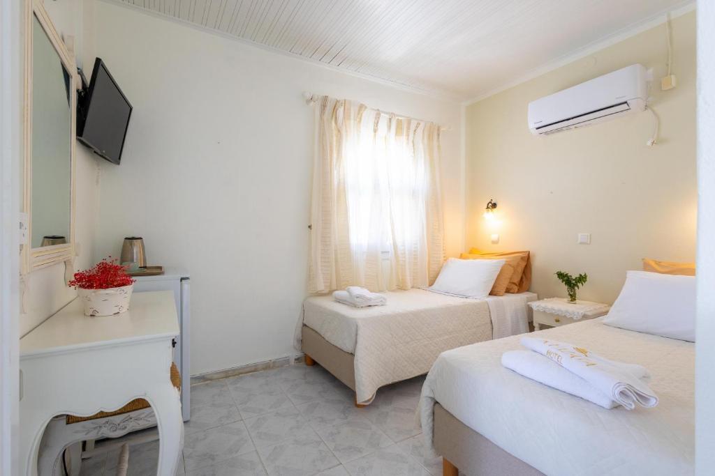 Postel nebo postele na pokoji v ubytování Kymata Hotel