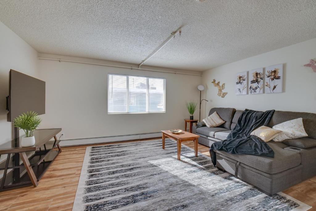 Cozy Anchorage Apartment with Mountain Views في أنكوراج: غرفة معيشة مع أريكة وطاولة