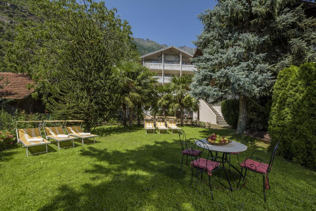un patio con sillas, una mesa y un edificio en Hotel Lamm, en Naturno