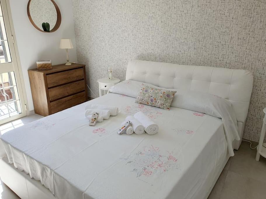 a white bed with two stuffed animals on it at Casa Svea in Avola