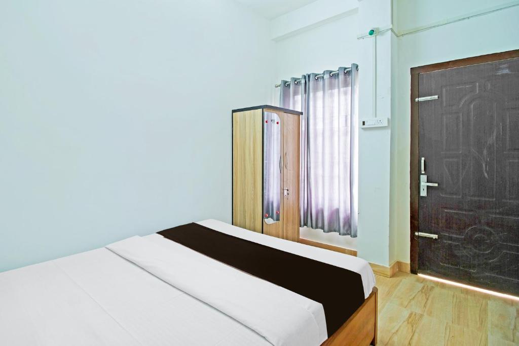 a bedroom with a bed and a black door at OYO Assam Inn Grand in Guwahati
