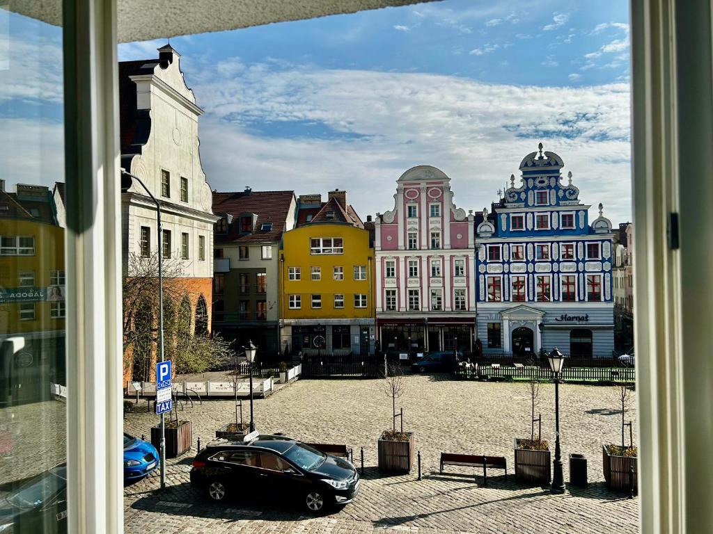 Blick auf eine Stadt mit einem Auto auf der Straße in der Unterkunft Old Town 2-Bedroom Apartment Sienny Market Square by Stayly in Stettin