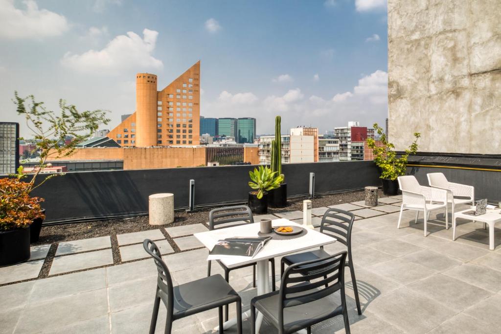 a patio with a table and chairs on a roof at ULIV Antara in Mexico City