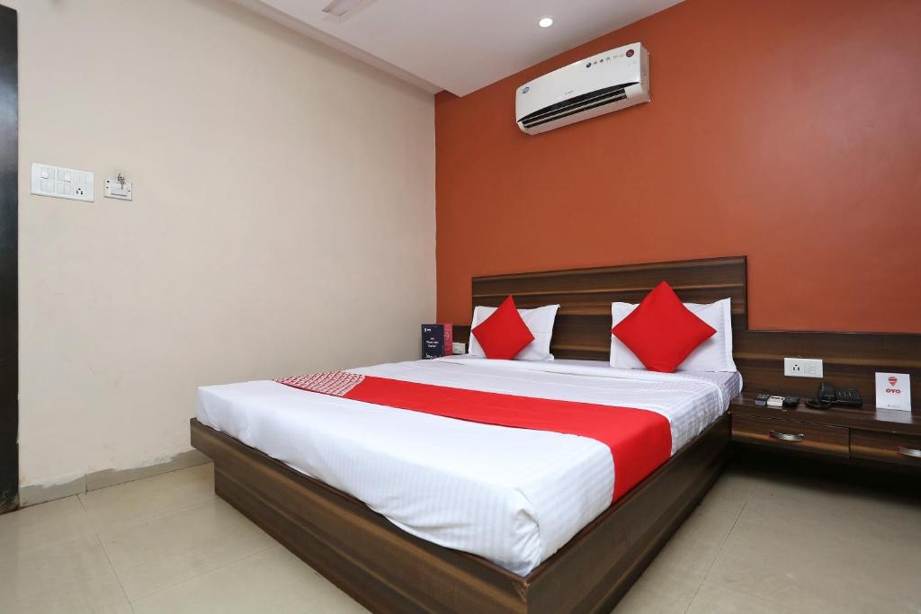 een slaapkamer met een groot bed met rode kussens bij Collection O Hotel City Star in Raipur