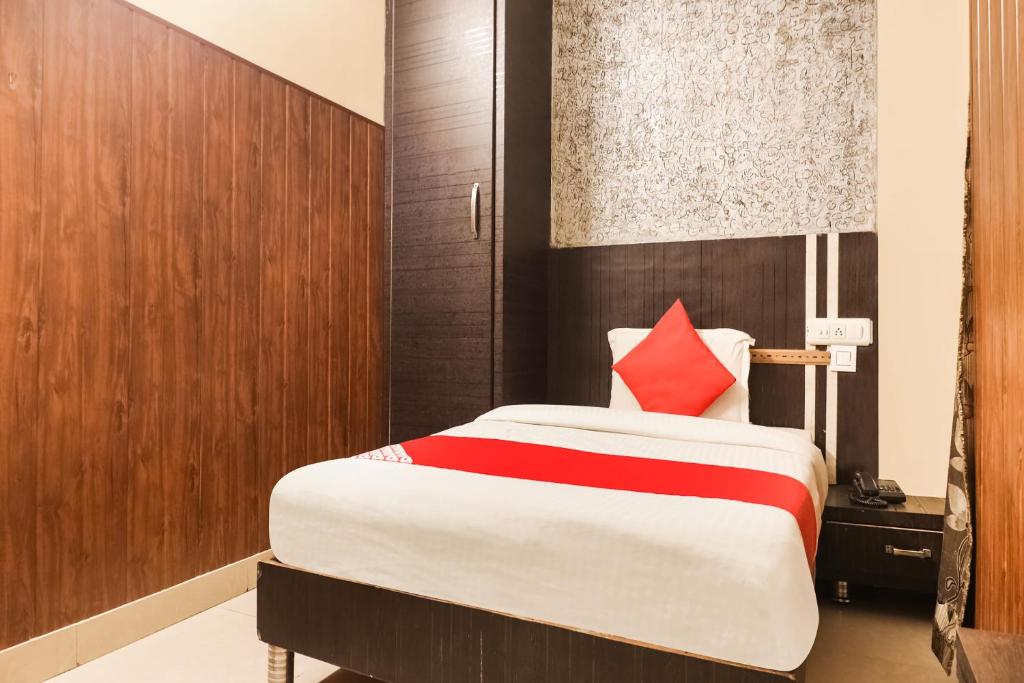 1 dormitorio con cama grande y almohada roja en OYO Hotel Moonlight en Hisār