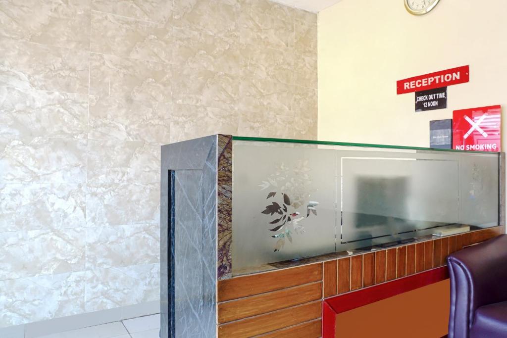 un aquarium de poissons dans une salle d'attente avec horloge dans l'établissement OYO Hotel paradise, à Mumbai