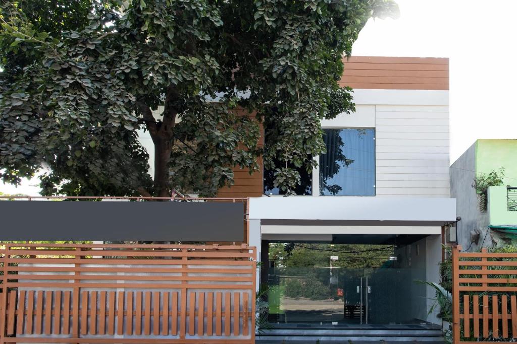 a house with a wooden fence and a tree at OYO Happy Home in Bhopal