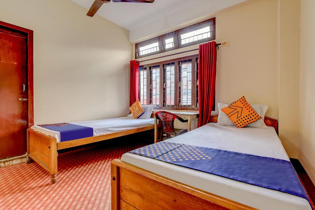 a room with two beds and a window at SPOT ON City Lodge Ganeshguri in Dispur