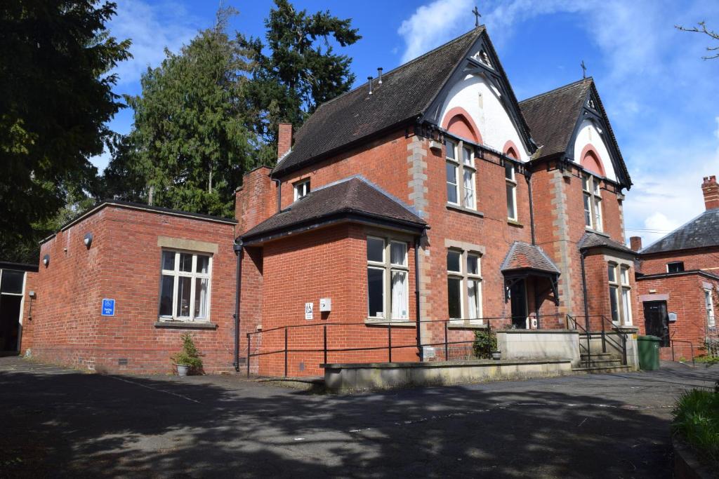 an old red brick building with a black roof at Kington Accommodation in Kington