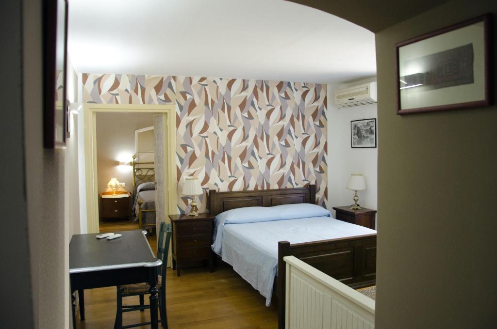 une chambre avec un lit, une table et un miroir dans l'établissement Appartamento Athena, à Bari