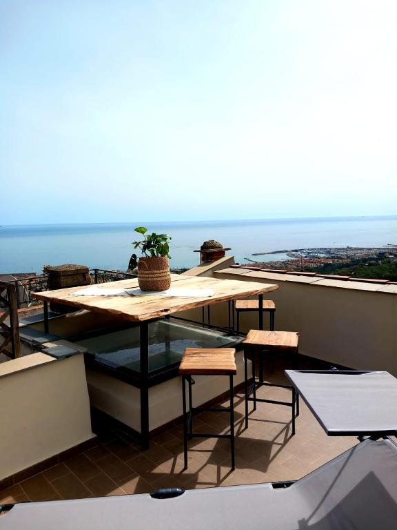 a table on a balcony with a view of the ocean at Hostdomus - Le Vigne sul Mare in Pietra Ligure