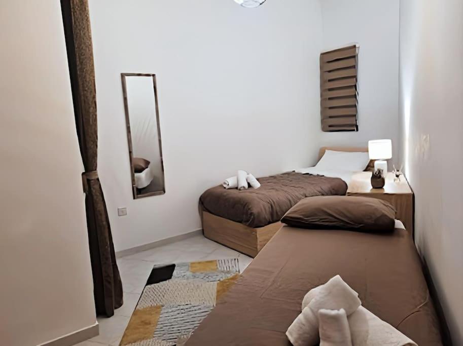 a bedroom with two beds and a mirror at Ruby Heaven Apartment in St Paul's Bay