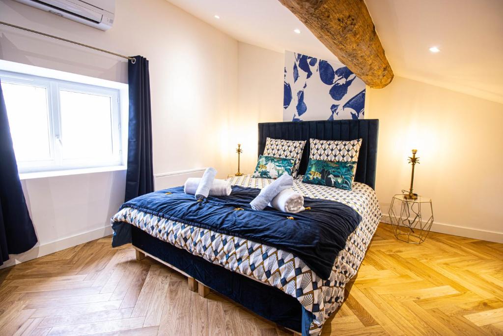 een slaapkamer met een bed met een blauw dekbed bij Suite Saphir - Jacuzzi & Sauna in Saint-Étienne