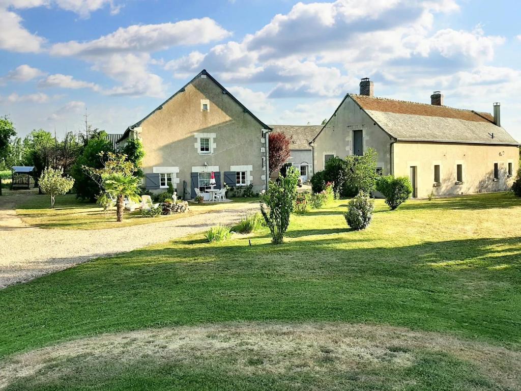 una gran casa blanca con un patio de césped en Studio avec jardin clos et wifi a Thilouze, en Thilouze