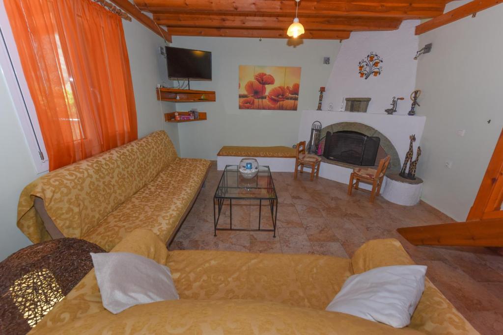 a living room with a couch and a fireplace at Country house in Limnionas in Ayía Kiriakí