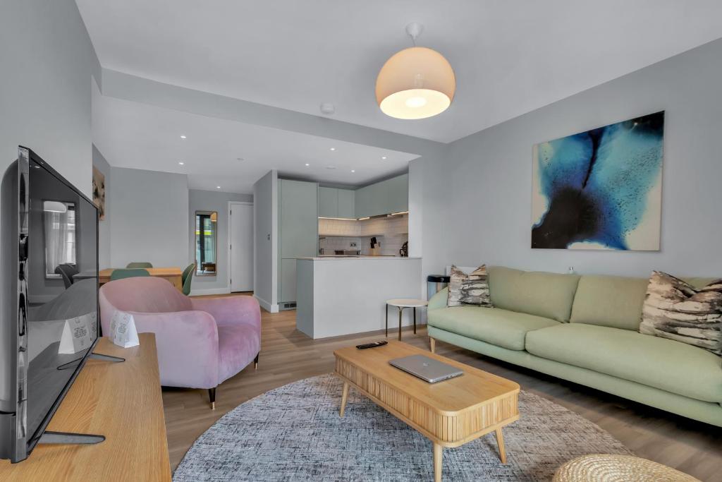ein Wohnzimmer mit einem Sofa und einem Tisch in der Unterkunft Spacious Two Bedroom Apartment at Wembley Park in London