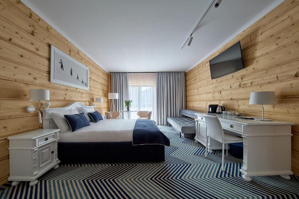 a hotel room with a bed and a desk and a desk at New Willa Jan in Zakopane