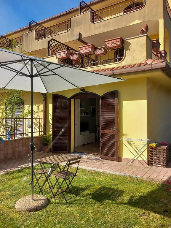 stół i parasol przed domem w obiekcie La casina delle Sorgentelle w mieście Bagni San Filippo