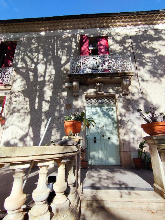 une maison avec une porte et un balcon avec des plantes en pot dans l'établissement villa marguerite, à Lunas