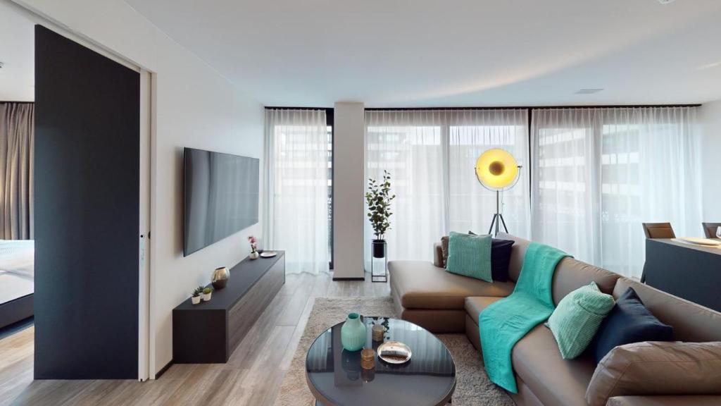 a living room with a couch and a tv at block E, 13 Sonnentalstrasse in Zurich