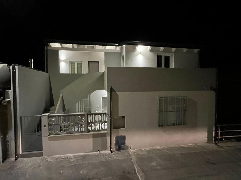a large white building with a balcony at night at Luciano Home in Gonnesa