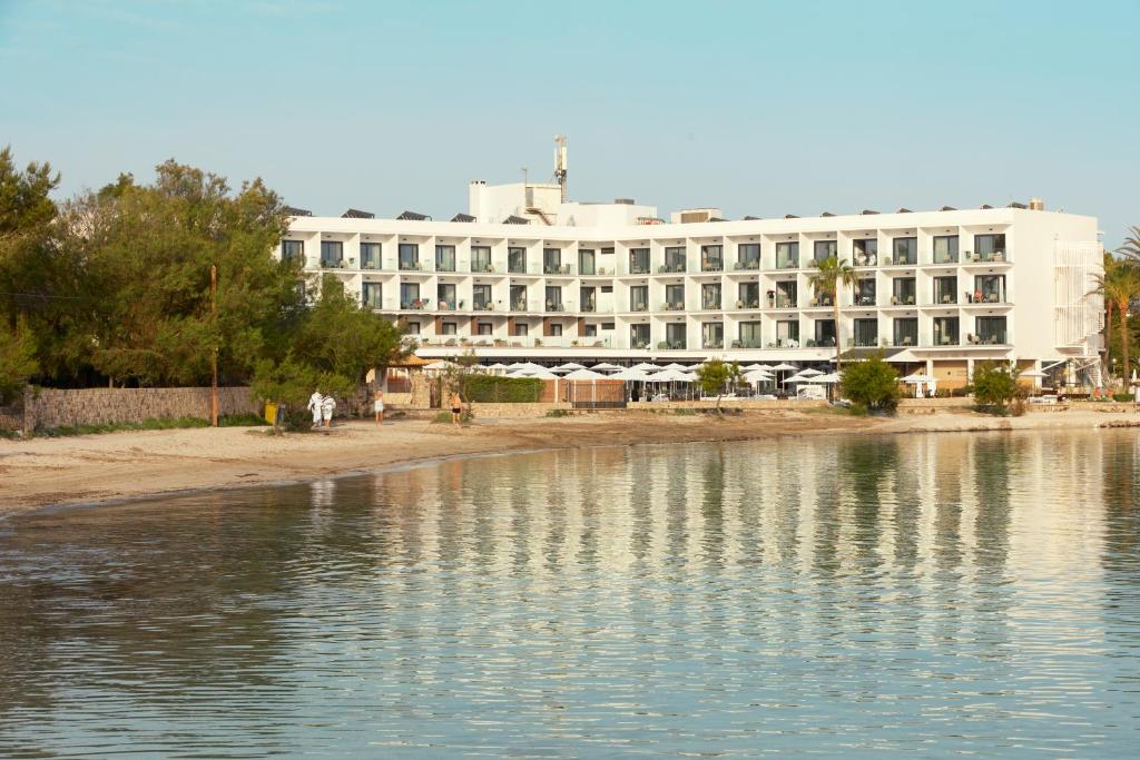 a large white building next to a body of water at Sunprime Pollensa Bay in Alcudia