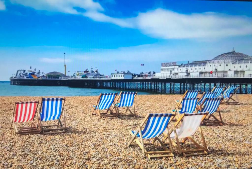 a group of lawn chairs sitting on a beach at Large light loft room - en suite in Brighton & Hove