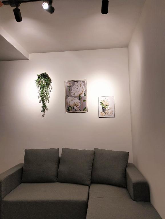 a living room with a couch and three pictures on the wall at Lazy Cabin PH in Manila