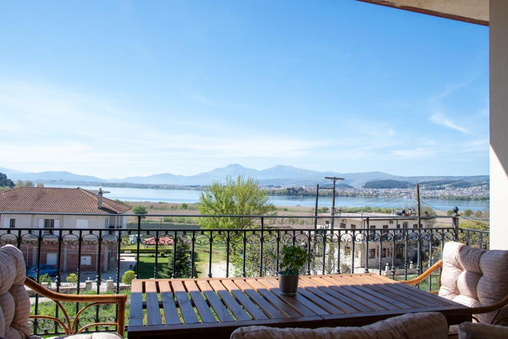 a table on a balcony with a view of the water at Lake House Ioannina in Ioannina