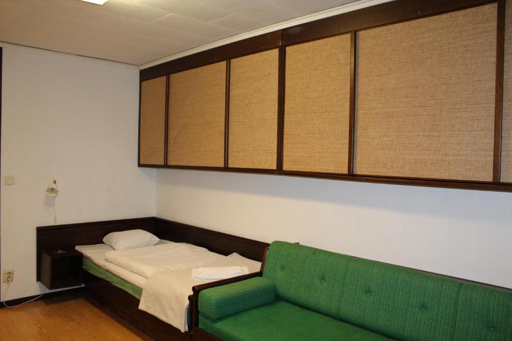 um quarto com uma cama e um sofá verde em Ali baba's Amigo, vandrarhem long stay em Emmaboda