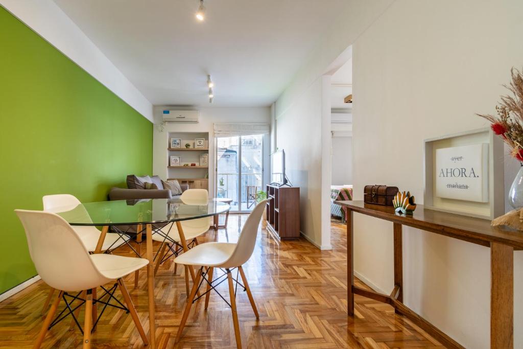 uma sala de jantar com uma mesa de vidro e cadeiras brancas em Departamento familiar con excelente ubicación - BA 3 em Buenos Aires