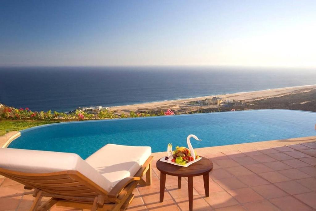 a swimming pool with a chair and a table with a swan at Astonishing 3BR Villa Magic View in Cabo San Lucas in Cabo San Lucas