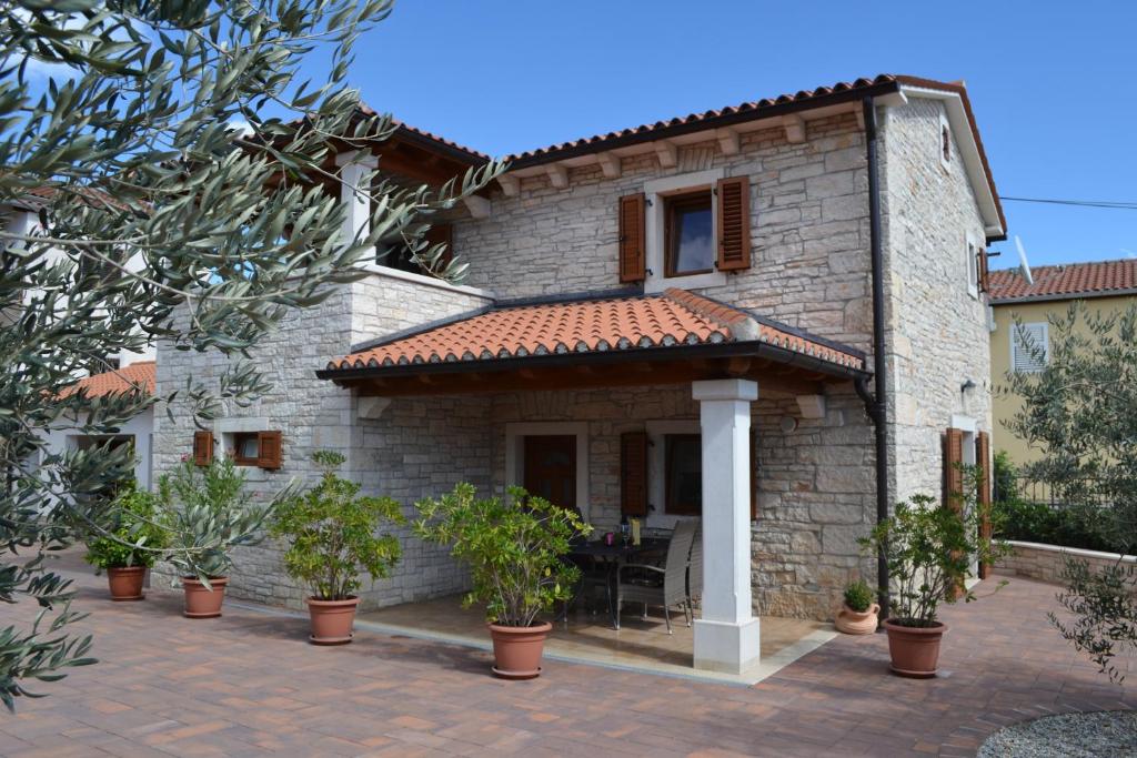 an external view of a house with a patio at Holiday Home Mate in Tinjan