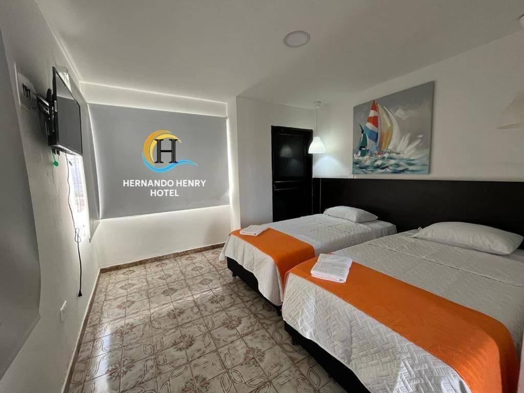 ein Hotelzimmer mit 2 Betten und einem Schild an der Wand in der Unterkunft HOTEL HERNANDO HENRY in San Andrés