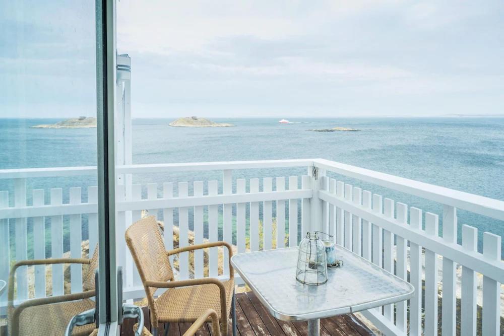 una mesa y sillas en un balcón con vistas al océano en Ekenäs Havshotell en Sydkoster