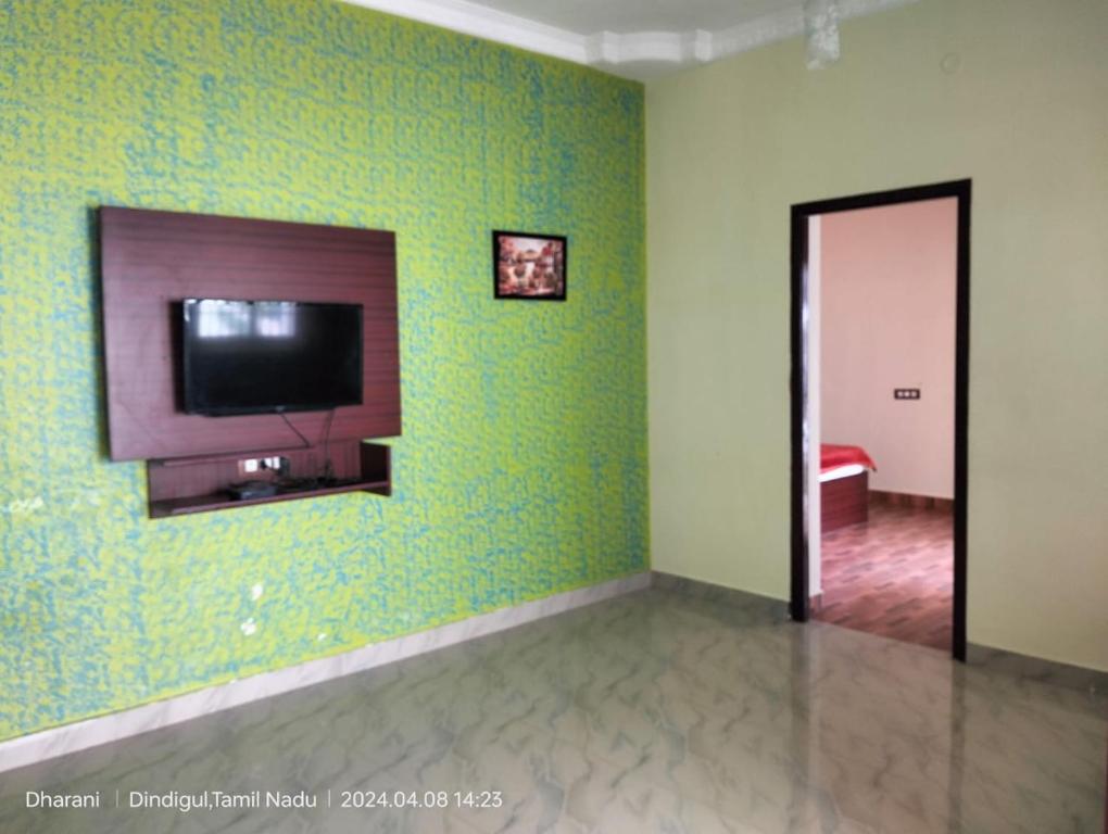 コダイカナルにあるSilver Mist villaの緑の壁に薄型テレビが備わる客室です。