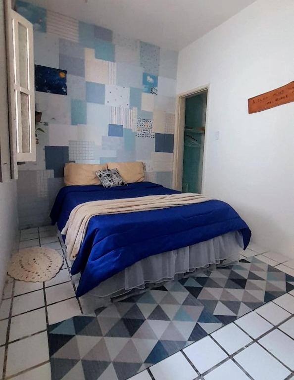 una camera da letto con un letto con una coperta blu sopra di Hospedaria Guapê a Lauro de Freitas