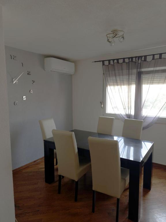 d'une salle à manger avec une table, des chaises et une fenêtre. dans l'établissement Stan - Mostar, à Mostar