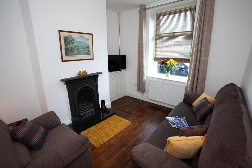 een woonkamer met een bank en een open haard bij Spacious 3 bedroom Cottage in Whalley in Whalley