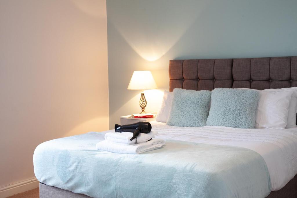 a bedroom with a large white bed with a stuffed animal on a towel at Spacious 3 bedroom Cottage in Whalley in Whalley